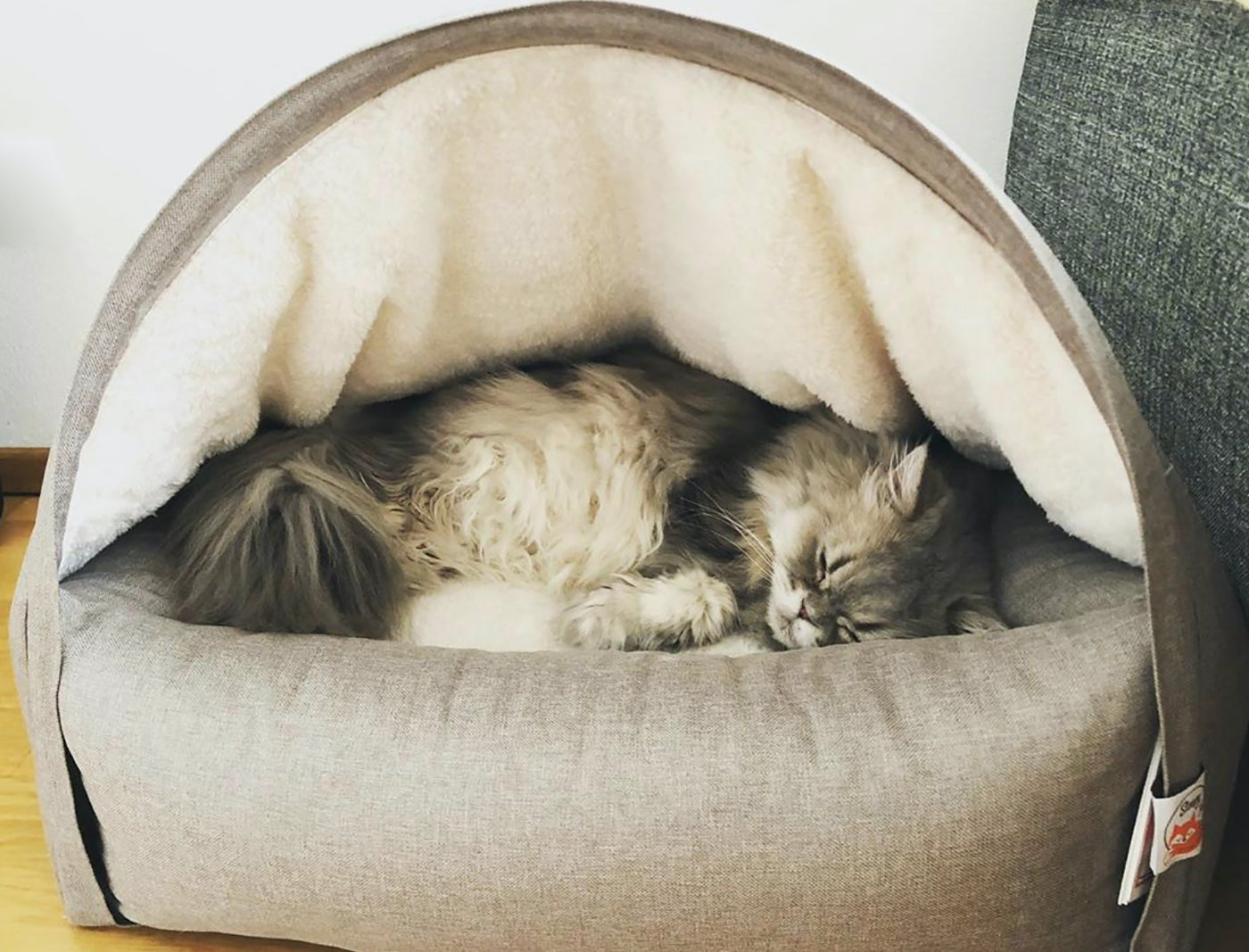 Persian cat sleeping inside a Snuggle Cat Cave Bed from Sleepy Fox® 